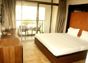 a hotel room with a bed and a balcony at Hotel Apaar in Diu +31 photos