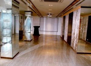 a large room with glass columns and a screen at Hotel Apaar in Diu