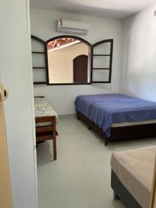 - une chambre avec un lit et un miroir dans l'établissement Casa estilo colonial, tranquila e perto de tudo!, à São Pedro da Aldeia