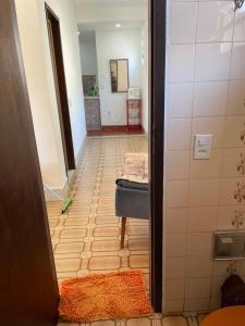 - un couloir menant à une salle de bains avec une table et une chambre dans l'établissement Casa estilo colonial, tranquila e perto de tudo!, à São Pedro da Aldeia