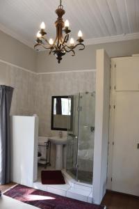 bagno con doccia e lampadario pendente di Poetry Guestrooms a Vryburg Altre 29 foto