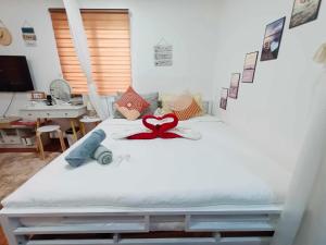 a white bed with a red heart on it at S&E-1 Tiny Guest House - Olango Island in Lapu Lapu City
