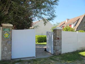 Saint-MolfにあるGîte Charmant avec Cheminée, Jardin Clos et Equipements Bébé à Proximité de la Côte - FR-1-306-842の庭の白いフェンスと門 +3枚の写真
