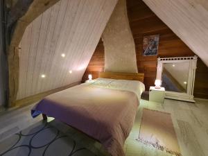 a bed in a room with an attic at À louer : Ancienne forge avec sauna, piscine, proche plage et sites historiques - FR-1-591-193 in Le Menoux +27 photos