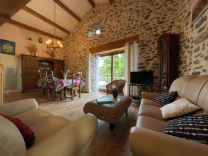 a living room with a couch and a table at Grange restaurée avec terrasse et wifi à La Bastide - FR-1-582-178 in Retournac