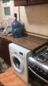 a kitchen with a stove and a washing machine at استوديو in Sharjah