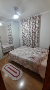 1 dormitorio con cama y alfombra en el suelo en Apartamento Viracopos Campinas en Viracopos