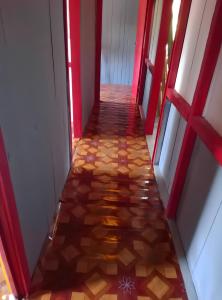 a hallway with red and white walls and a tile floor at Casas Salomão in Santo António