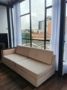 um sofá num quarto com uma grande janela em El Castillo em Bogotá
