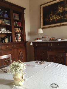 a dining room with a table with a vase of flowers at Dedicato A Te in Montelupone