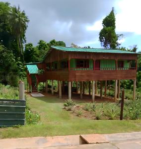 ein großes Holzhaus mit grünem Dach in der Unterkunft Casas Salomão in Santo António
