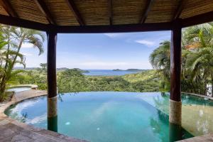 a swimming pool with a view of the ocean at Villa Durazno in Guanacaste