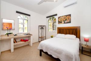 a bedroom with a bed and a sink and two windows at Orquideas Villas & Studios at Country House in Cancún