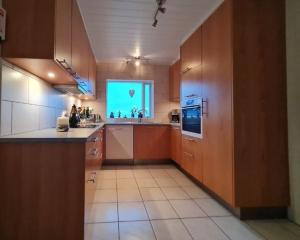 uma grande cozinha com armários de madeira e um ecrã verde em Ibúð með einstöku útsýni em Sauðárkrókur