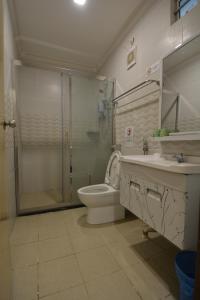 a bathroom with a shower and a toilet and a sink at Hemingway Cottage 海明威度假屋 in Semporna