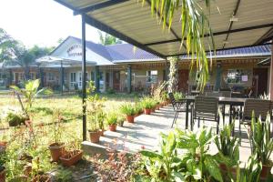 a patio with a table and chairs and plants at Hemingway Cottage 海明威度假屋 in Semporna