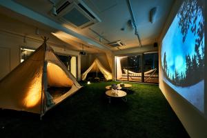 een kamer met een tent, een tafel en een tv bij Cocts Akihabara in Tokyo