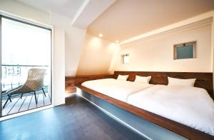 een slaapkamer met een bed en een groot raam bij Cocts Akihabara in Tokyo