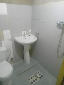 a white bathroom with a sink and a toilet at Casas Salomão in Santo António