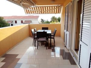 a balcony with a table and chairs on it at VIP, Zrce, Gajac, Above Main Square, Best Location in Gajac