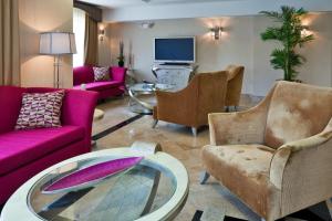 uma sala de estar com mobiliário rosa e uma prancha de surf numa mesa em Holiday Inn Express Hotel & Suites Birmingham - Inverness 280, an IHG Hotel em Birmingham
