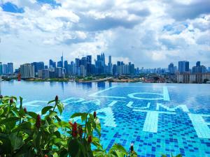 a large swimming pool with a city in the background at Datum Jelatek Residences Royalty Luxury Apartment, Walking Distance To LRT, Gleneagles KL & KLCC in Kampong Datok Keramat
