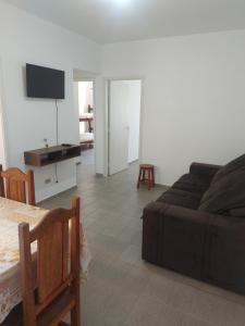 a living room with a couch and a flat screen tv at Apartamento na Praia dos Sonhos Perto do Mar em Itanhaém in Itanhaém