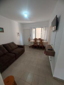 Apartamento na Praia dos Sonhos Perto do Mar em Itanhaém في إيتانهايم: غرفة معيشة مع أريكة وطاولة