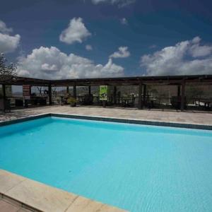 a large blue swimming pool in front of a building at Monte Castelo in Bezerros