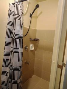 a shower with a black and white shower curtain at Avida Tower 3 Unit 606 in Iloilo City