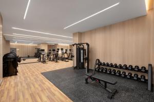 a gym with a bunch of equipment in a room at voco Lianyungang Haizhou Bay, an IHG Hotel in Lianyungang