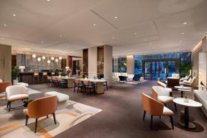 - un hall d'un hôtel avec des tables et des chaises dans l'établissement voco Lianyungang Haizhou Bay, an IHG Hotel, à Lianyungang