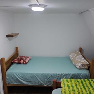 a small bedroom with a bed and a ceiling at Backpackers House - Near The Airport in Santiago