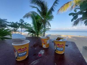 three buckets of food sitting on a table near the beach at Magic's Place Beach Resort in Moalboal