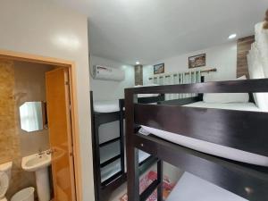 two bunk beds in a room with a bathroom at Ma Garbo Hotspring Private Resort in Calamba