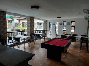 una mesa de billar en una habitación con mesas y sillas en Ma Garbo Hotspring Private Resort, en Calambá