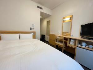 a hotel room with a bed and a television at Hotel Route-Inn Kushiro Ekimae in Kushiro +36 photos
