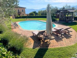 uma piscina com duas cadeiras e um guarda-sol em Pool Villa Yoga studio Spoleto Tranquilla - A sanctuary of dreams and peace em Morro