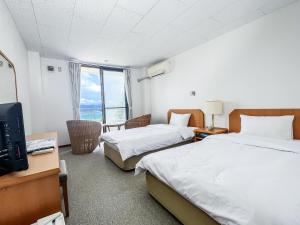 a hotel room with two beds and a television at Kerama Blue Resort in Zamami