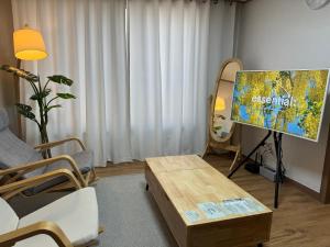 a living room with a tv and a table at Green Stay in Suwon