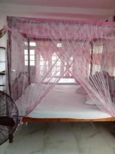 a bedroom with a bed with pink mosquito netting at Old Town Hotel in Kandy
