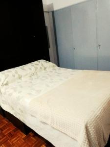 ein Bett mit einer weißen Decke darüber in der Unterkunft Florida Bedchamber in Buenos Aires
