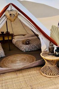 Zelt mit einem Bett und einem Tisch in der Unterkunft Duna Camp Huacachina in Ica
