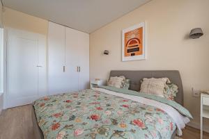 een slaapkamer met een bed met een bloemenbed bij Cozy apartment with huge terrace in Vilnius