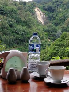 a bottle of water sitting on a table with cups at Super View in Ella