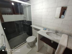 a bathroom with a toilet and a sink and a shower at Caza Floripa in Florianópolis