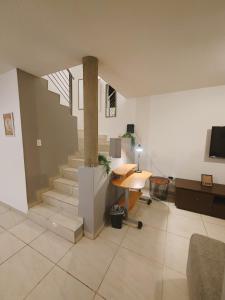 a living room with a staircase and a table at Casa Real San Marcos B en Privada Zona Norte in Irapuato