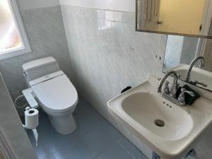 y baño con aseo blanco y lavamanos. en Quesada Homestay, en San Francisco