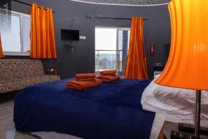 a bedroom with a blue bed with orange curtains at Bojang River Lodge in Bakau