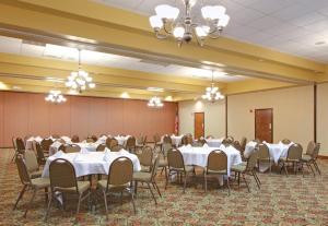 un salón de banquetes con mesas y sillas blancas en Holiday Inn Blytheville, an IHG Hotel, en Blytheville